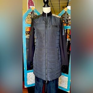 Black knee length jacket. Leather like shoulders and 3 functional pockets.